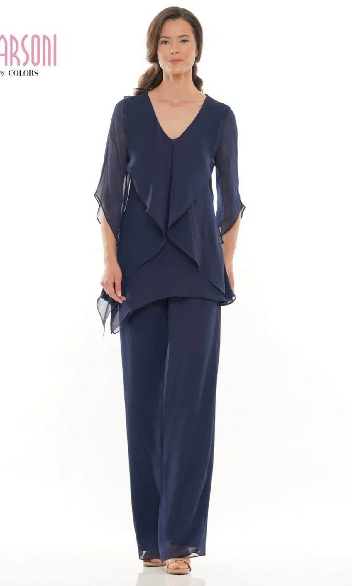 A woman stands against a white background wearing the navy Long Formal Pantsuit: Marsoni M308, featuring a layered chiffon top with matching wide-leg pants and beige open-toe shoes.